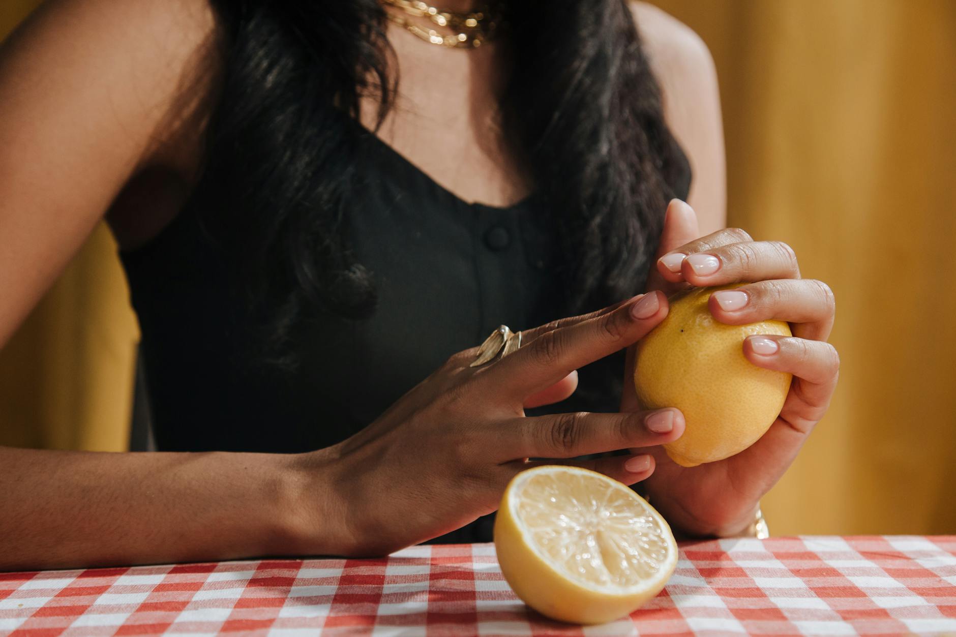 Close-up of a woman holding a fresh lemon, symbolizing renewal and fresh perspective on intimacy.