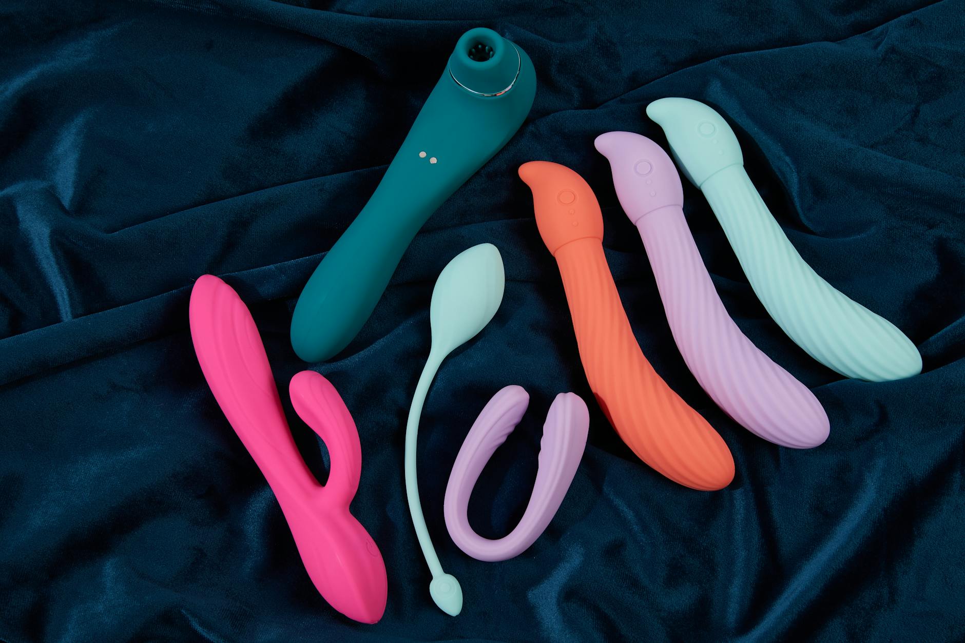A yellow lemon clitoral vibrator surrounded by fresh fruit on a warm yellow background, symbolizing desire and pleasure