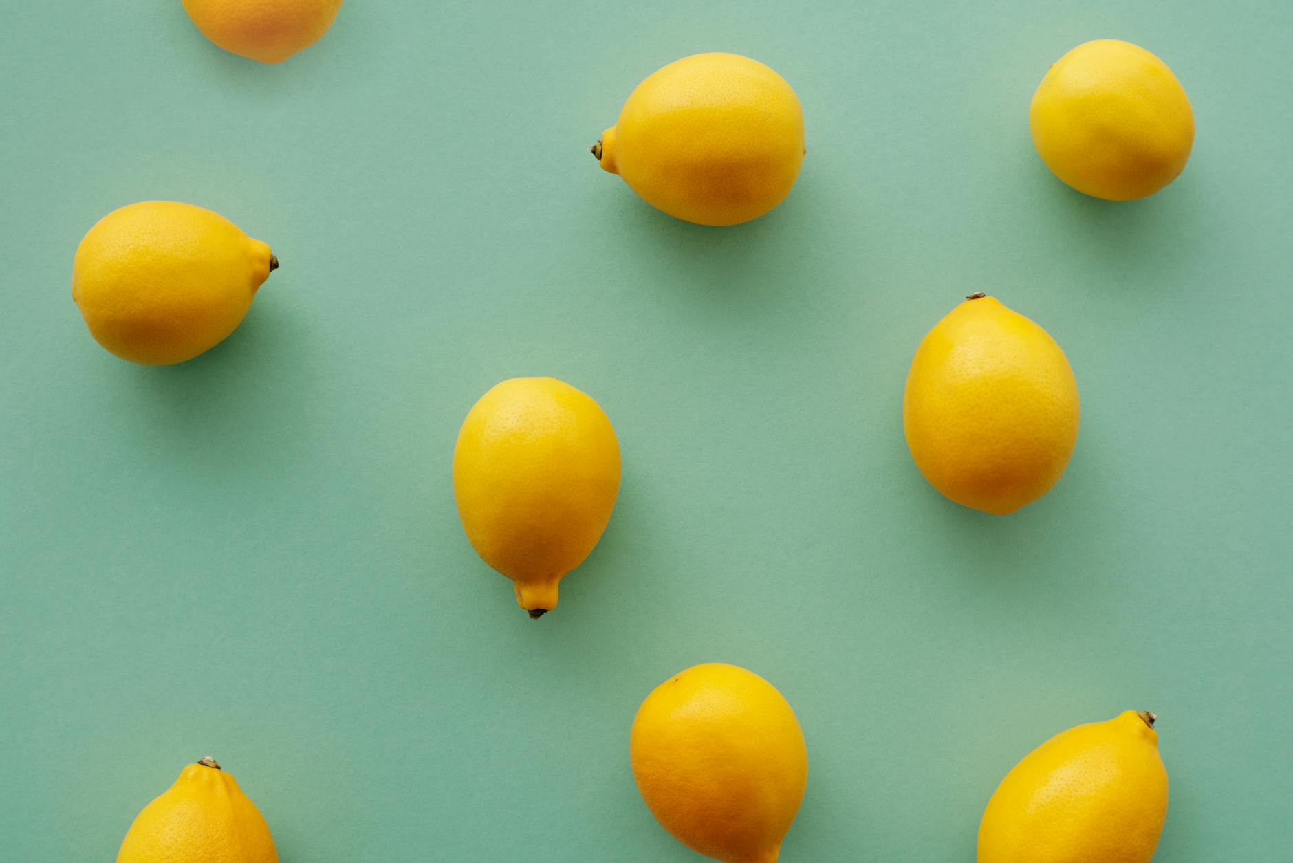 Bright yellow lemons arranged on a pastel background, representing the playful design of Hello Nancy's Lems lemon clitoral vibrators