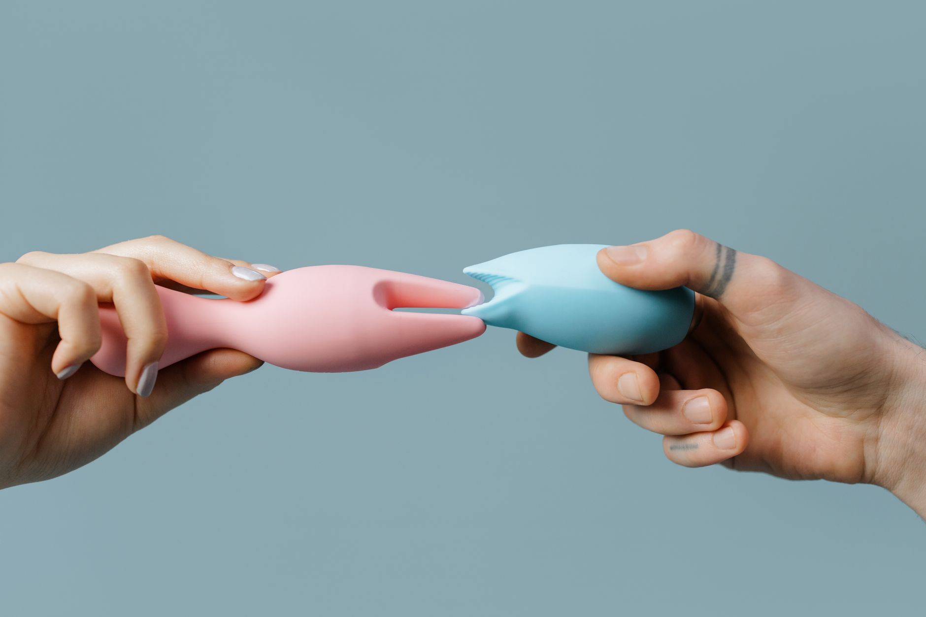 Close-up of a woman holding a pink vibrator, symbolizing personal pleasure and intimate wellness.