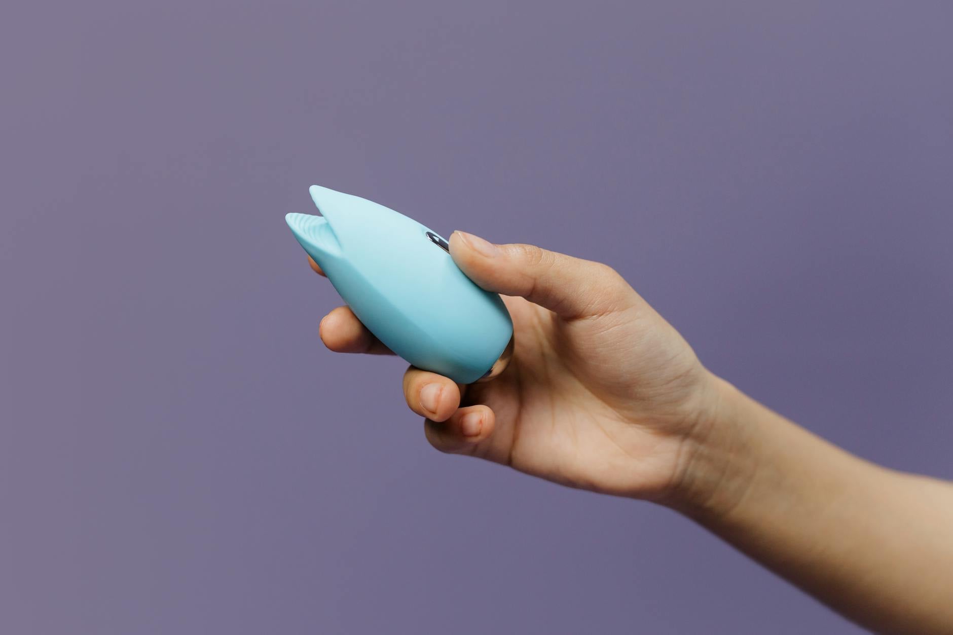 A sleek lemon-colored vibrator held in hand against a soft background, representing quick, accessible pleasure for busy partners.