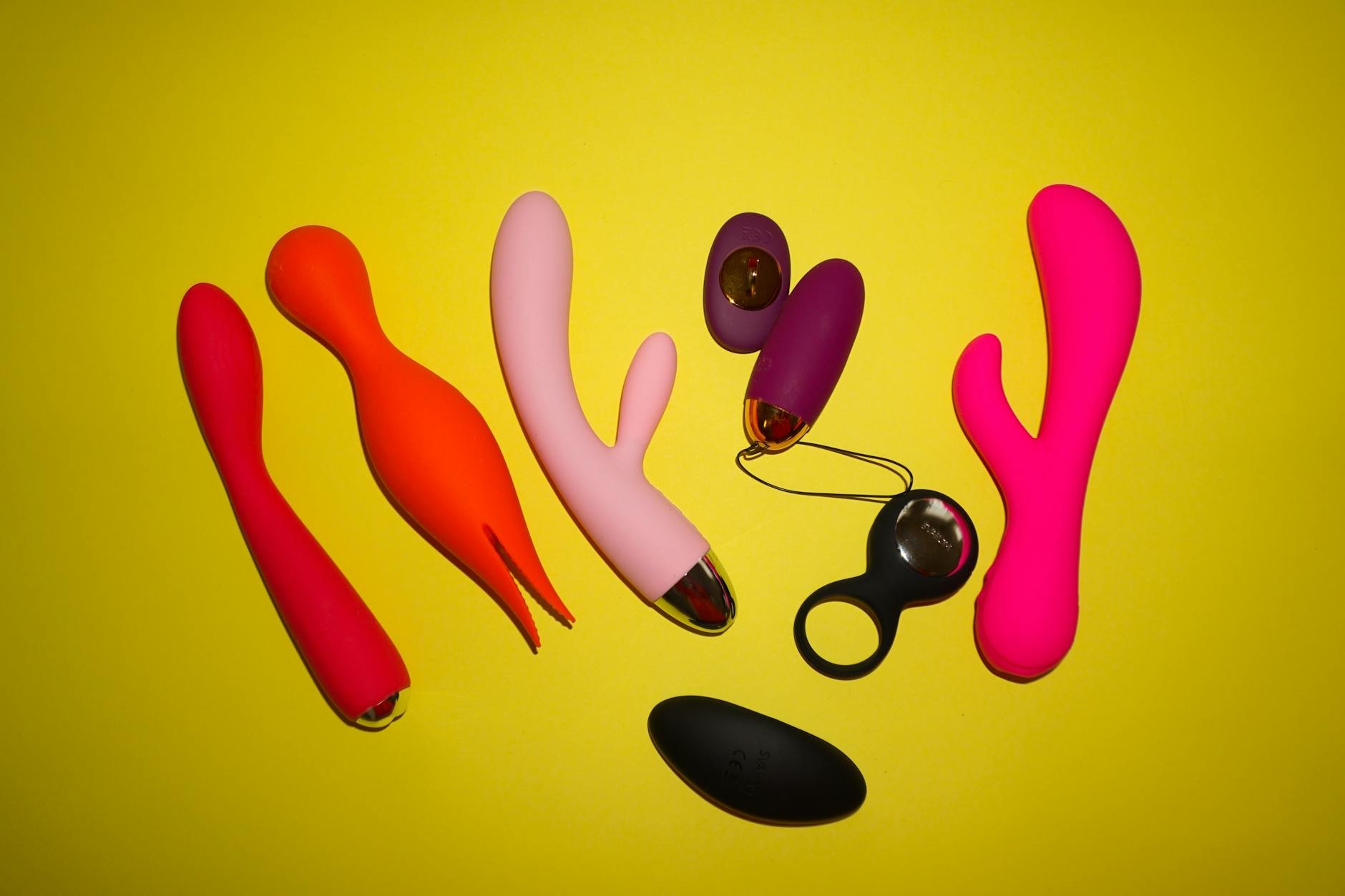 Colorful adult toys displayed on a bright yellow background